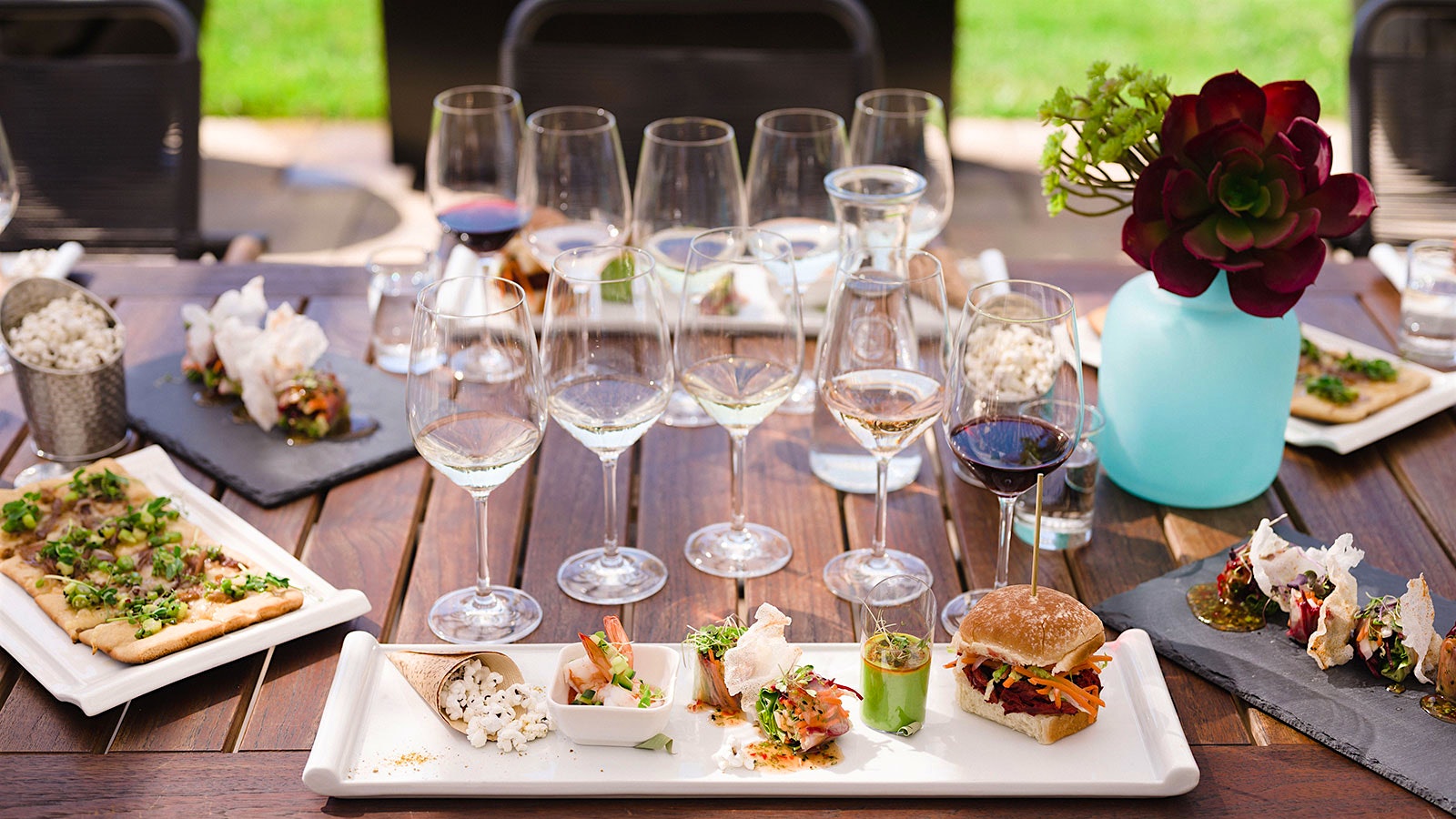 A table laden with small plates and flights of wine